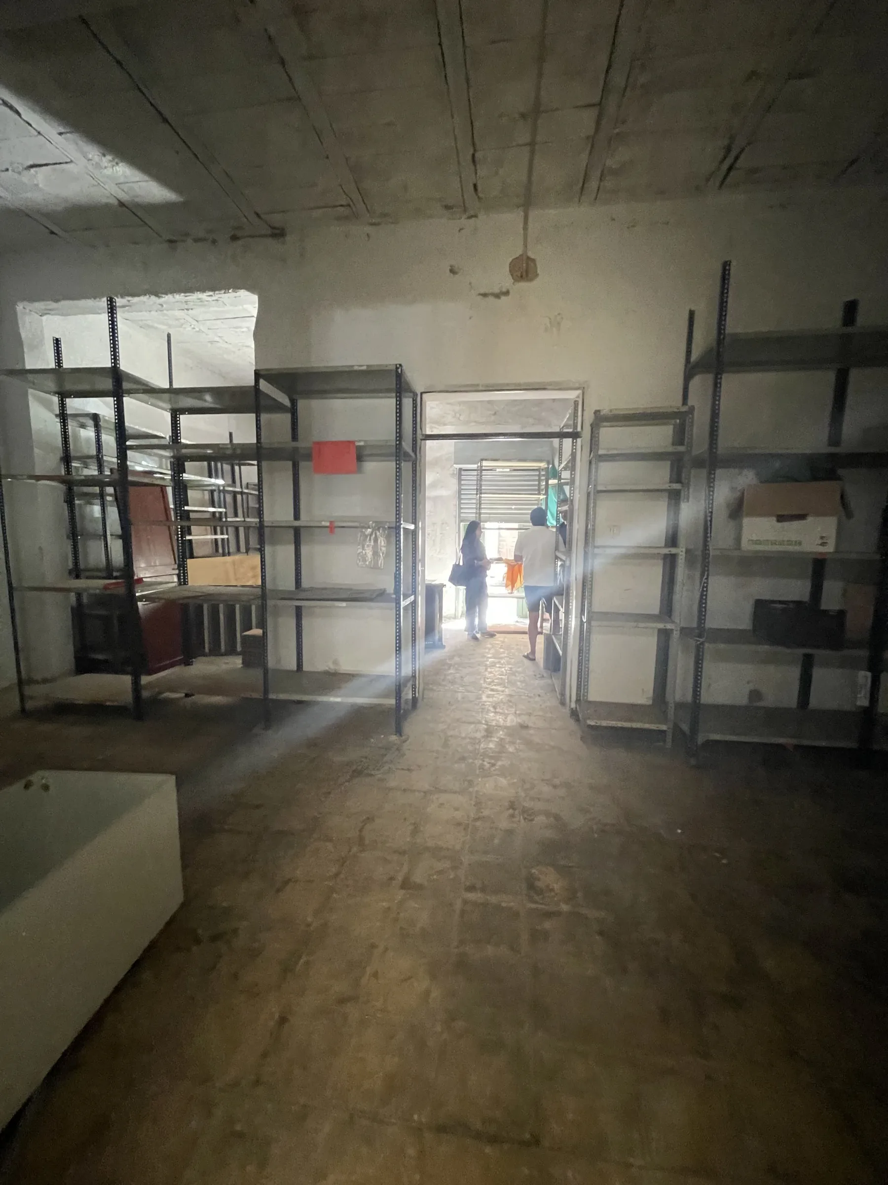 Long interior room with original shelving and a view towards the street opening